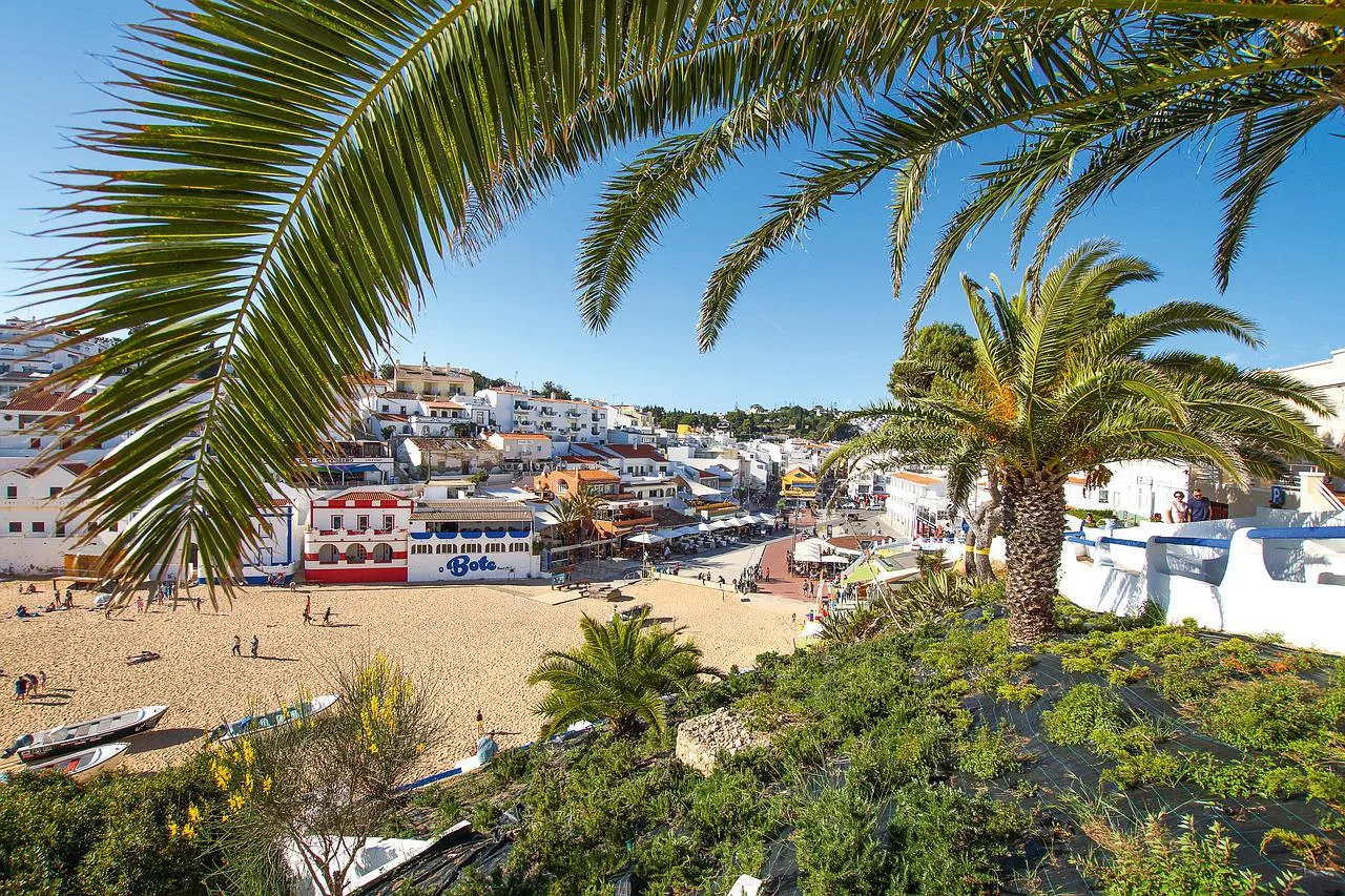 Vila algarvia debruçada sobre o areal, com barcos de pesca na areia